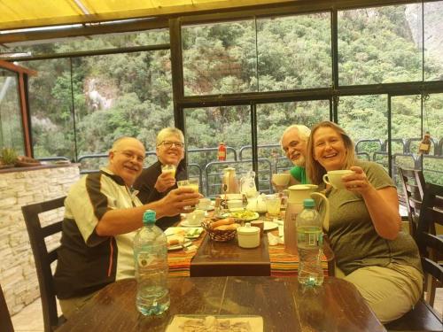 a group of people sitting at a table drinking coffee at RUMIQOLQA Machupicchu Hotel in Machu Picchu
