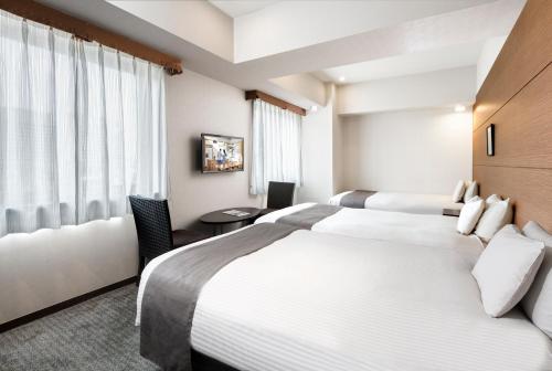 a hotel room with two beds and a window at Citadines Central Shinjuku Tokyo in Tokyo