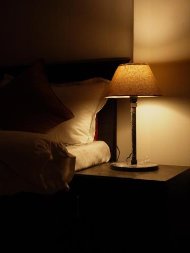 a lamp sitting on a table next to a bed at Light House By Leisure Hospitality in Rishīkesh