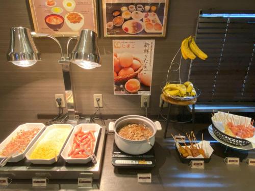 a buffet with many different types of food on a counter at Astil Hotel Shinosaka Precious in Osaka