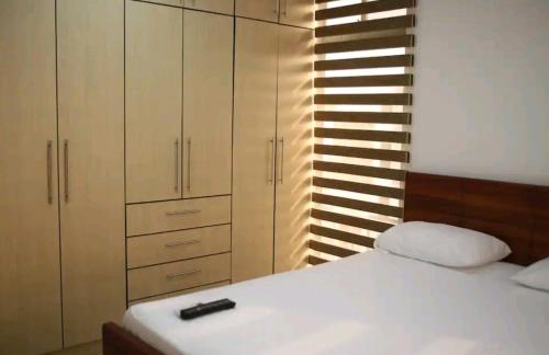 a bedroom with a white bed and a cabinet at Sky Blue Apartments in Manta