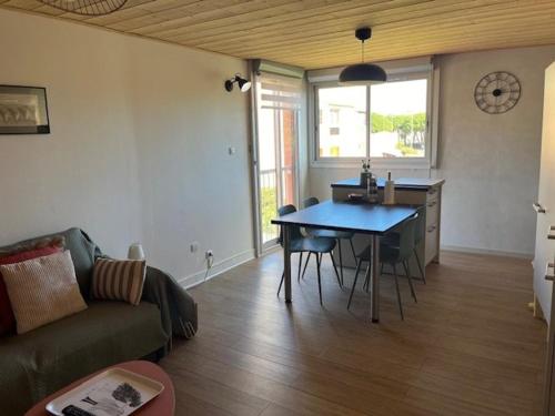 un salon avec une table et un canapé dans l'établissement Charmant T2 rénové, parking privé, proche plage et commerces, idéal déplacement à pied - FR-1-749-56, au Cap d'Agde
