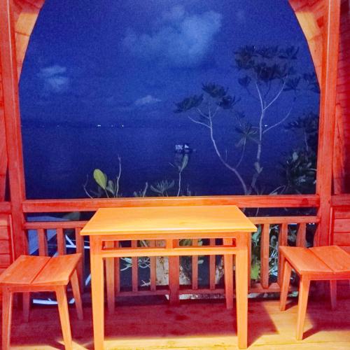 a table and two chairs in front of a window at Bunaken 18 Diving Resort and Cafe in Bunaken