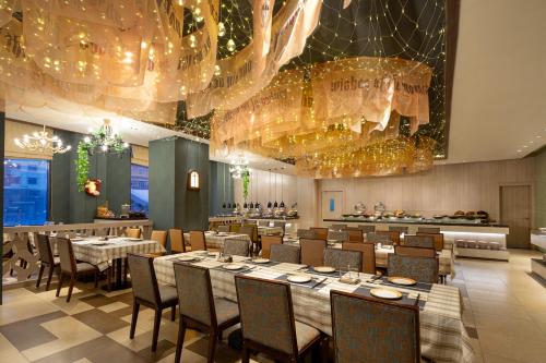 Un comedor con mesas, sillas y candelabros. en Wanda Momoland Changbaishan, en Fusong