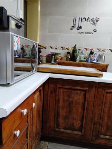 a kitchen with wooden cabinets and a microwave at Casa Di Patti B & B in Santiago