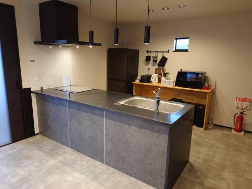 a kitchen with a sink and a refrigerator at モントゥトゥ-Montoutou- in Hasunuma