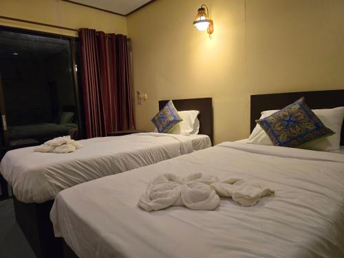 two beds in a hotel room with towels on them at Khao Sok Horizon in Ban Bang Thong