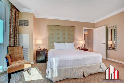a bedroom with a large white bed and a chair at MGM Signature-21-701 1Br2Ba F1 Strip View Balcony in Las Vegas
