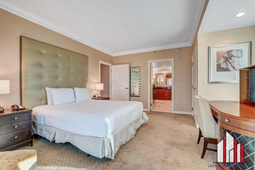 a bedroom with a large white bed and a desk at MGM Signature-21-701 1Br2Ba F1 Strip View Balcony in Las Vegas