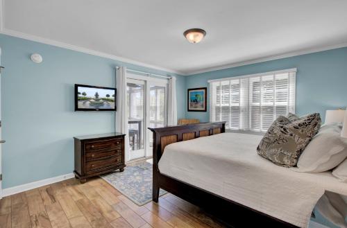 Schlafzimmer mit blauen Wänden, einem Bett und einem Fenster in der Unterkunft 29 Ocean Point AvantStay Luxe Kitchen Balcony in Isle of Palms
