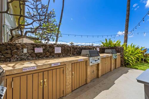 a row of wooden gates in front of a stone wall at Nani Kai Hale 208- Beachfront 1 bedroom 2 bathroom condo, oceanview in Kihei