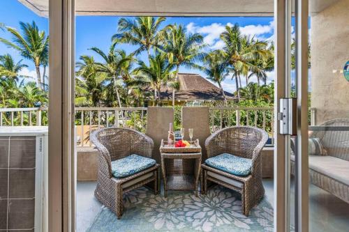 a patio with two chairs and a table on a balcony at Nani Kai Hale 208- Beachfront 1 bedroom 2 bathroom condo, oceanview in Kihei
