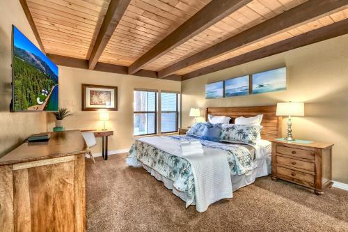a bedroom with a bed and a desk and windows at Lakeland Village 521 - Come Lake It in South Lake Tahoe