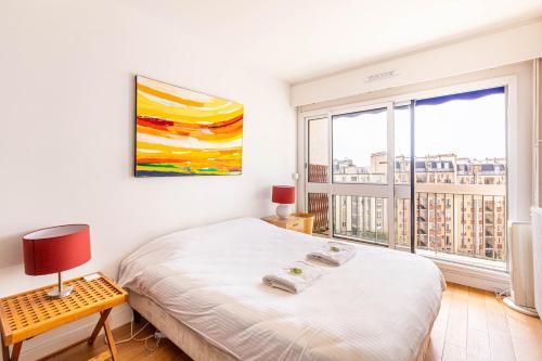 une chambre avec un lit et une grande fenêtre dans l'établissement GuestReady - Bright and airy in the 18th, à Paris