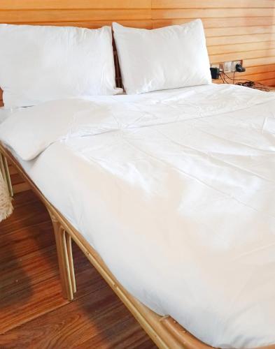 an unmade bed with white sheets and pillows at Bunaken 18 Diving Resort and Cafe in Bunaken
