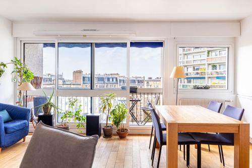un salon avec une table et une grande fenêtre dans l'établissement GuestReady - Bright and airy in the 18th, à Paris