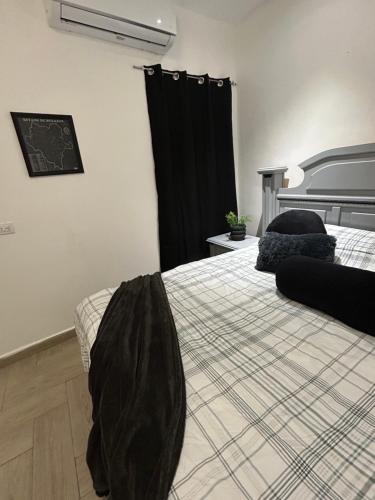 - une chambre avec un lit et un rideau noir dans l'établissement Casa 4 Personas, céntrica, patio amplio, à Ciudad Lerdo