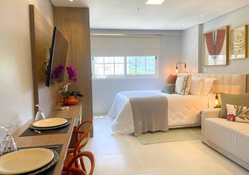 Loft luxuoso na Serra - Granja Brasil Resort في بتروبوليس: غرفة نوم مع سرير وغرفة معيشة