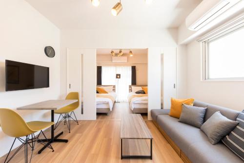 a living room with a couch and a table at SG RESIDENCE INN HAKATA in Fukuoka