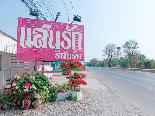 a sign for a hotel on the side of a street at Saan Rak Resort in Prachuap Khiri Khan