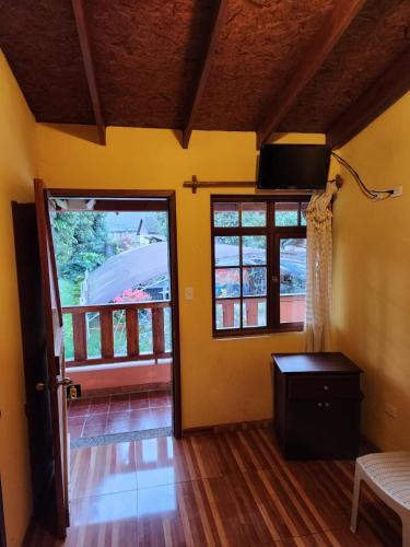 a living room with a door and a balcony at Fuentes del Volcán in Baños