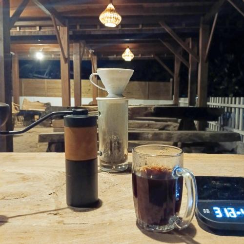 a cup of coffee sitting on a wooden table with a drink at Bunaken 18 Diving Resort and Cafe in Bunaken