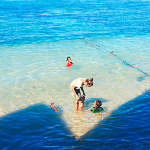 a man and three children in the water at Bunaken 18 Diving Resort and Cafe in Bunaken