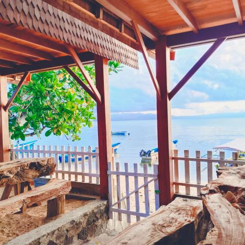 a view of the ocean from the porch of a house at Bunaken 18 Diving Resort and Cafe in Bunaken