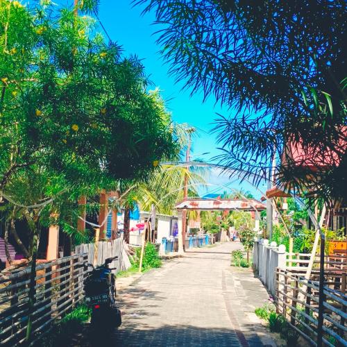 a street in a town with trees and a fence at Bunaken 18 Diving Resort and Cafe in Bunaken