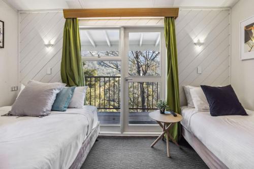 two beds in a room with a window at Tyrola 2 in Thredbo