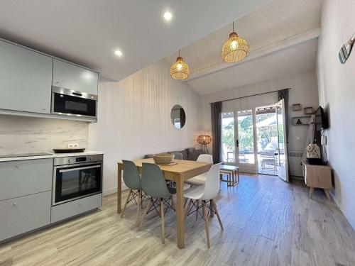 une cuisine et une salle à manger avec une table et des chaises dans l'établissement Mazet climatisé avec jardin, piscine privée et proche mer, 3 pièces, 6 couchages à Sainte-Maxime - FR-1-226-545, à Sainte-Maxime