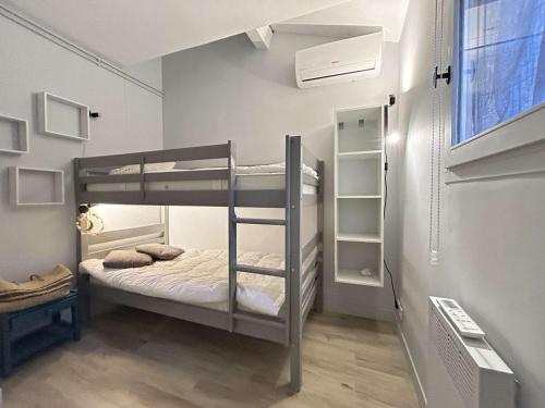 une chambre avec deux lits superposés et une fenêtre dans l'établissement Mazet climatisé avec jardin, piscine privée et proche mer, 3 pièces, 6 couchages à Sainte-Maxime - FR-1-226-545, à Sainte-Maxime