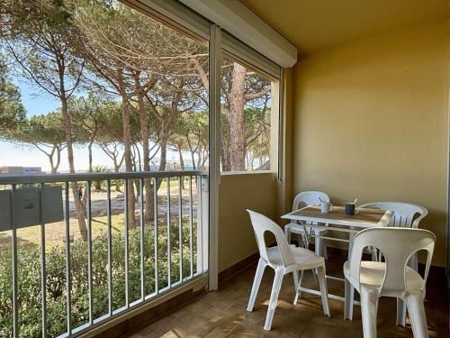 une salle à manger avec une table et des chaises et une grande fenêtre dans l'établissement Appartement 2 pièces/cabine, accès plage direct, parking privé, loggia, 4 couchages - FR-1-225-812, à Argelès-sur-Mer