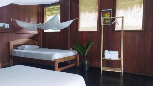 River Point Hostel في بويرتو مالدونادو: غرفة نوم بسريرين وطاولة