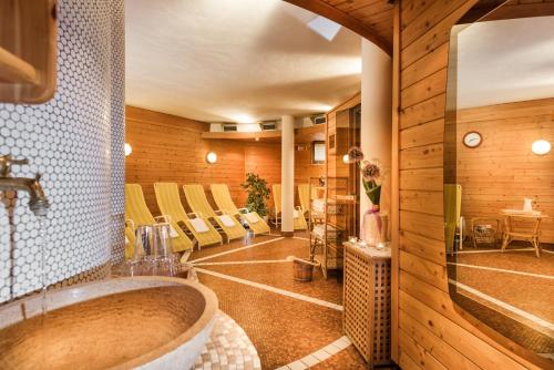 ein Badezimmer mit einer großen Badewanne in einem Zimmer mit Stühlen in der Unterkunft Landhotel Steindlwirt in Dorfgastein