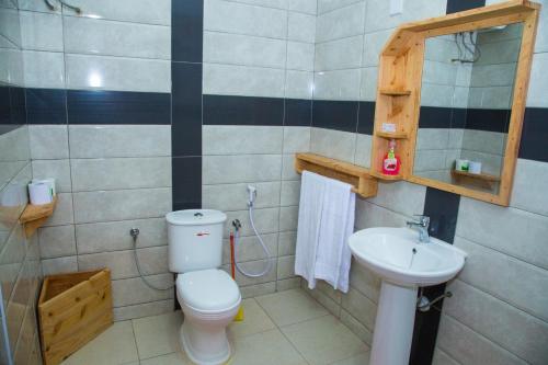 a bathroom with a toilet and a sink at Swiss Farm Cottage in Lushoto