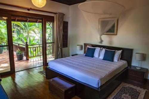 um quarto com uma cama e uma varanda em VILLA MASSILIA em Siem Reap