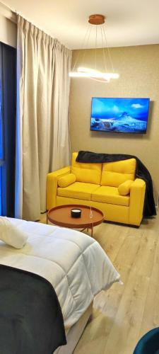 a living room with a yellow couch and a table at Republica del Salvador Coliving Ecuador XOE in Quito