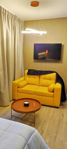 a living room with a yellow couch and a table at Republica del Salvador Coliving Ecuador XOE in Quito