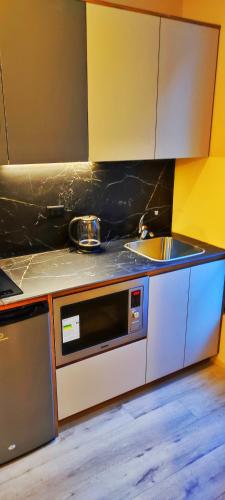 a kitchen with a sink and a microwave at Republica del Salvador Coliving Ecuador XOE in Quito