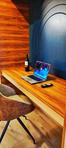 a laptop on a wooden desk with a bottle of wine at Republica del Salvador Coliving Ecuador XOE in Quito