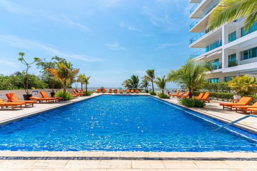 a swimming pool with orange chairs and a building at Morros 3 in Cartagena de Indias