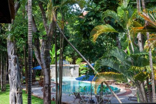 um resort com uma piscina com palmeiras em VILLA MASSILIA em Siem Reap