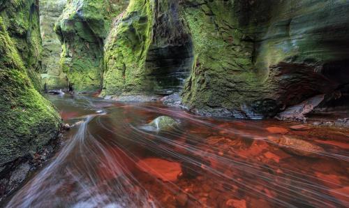 a long exposure photo of a stream in a canyon at The Mar Huts - The Lomond Hut in Drymen