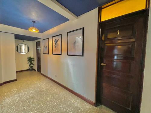 a hallway with a door and pictures on the walls at Hotel Citadin Z10 in Guatemala