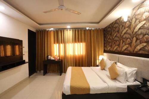 a hotel room with a bed and a television at Hotel Aashiyana Palace Just 4Km Away From Delhi Airport in New Delhi