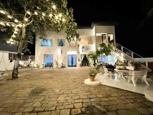 a large white building with a courtyard at night at Evergreen Tree Homestay in Phan Thiet