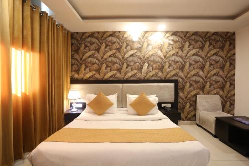 a hotel room with a bed and a wall mural at Hotel Aashiyana Palace Just 4Km Away From Delhi Airport in New Delhi