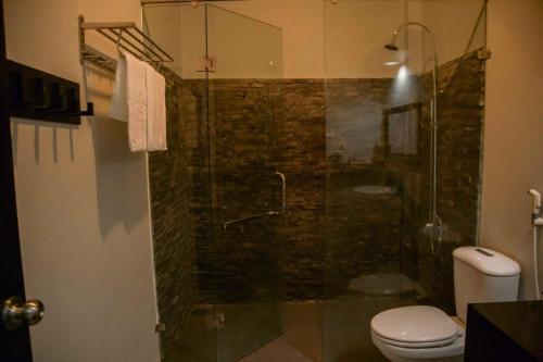 a bathroom with a glass shower with a toilet at Evergreen Tree Homestay in Phan Thiet