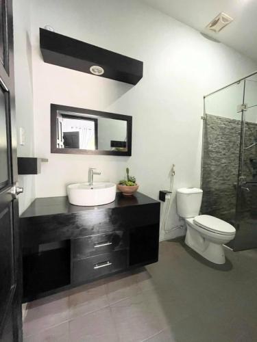 a bathroom with a sink and a toilet and a mirror at Evergreen Tree Homestay in Phan Thiet
